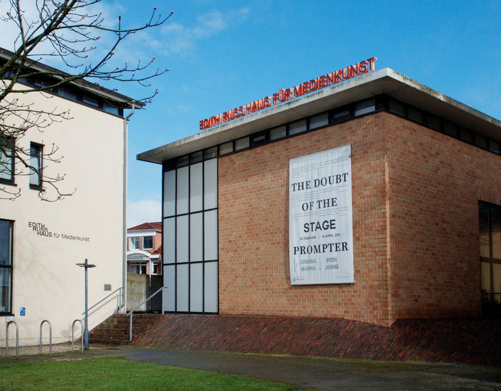 Das Foto zeigt die Fassade des Edith-Russ-Hauses mit dem Banner der Ausstellung The Doubt of the Stage Prompter. Foto © Edith-Russ-Haus