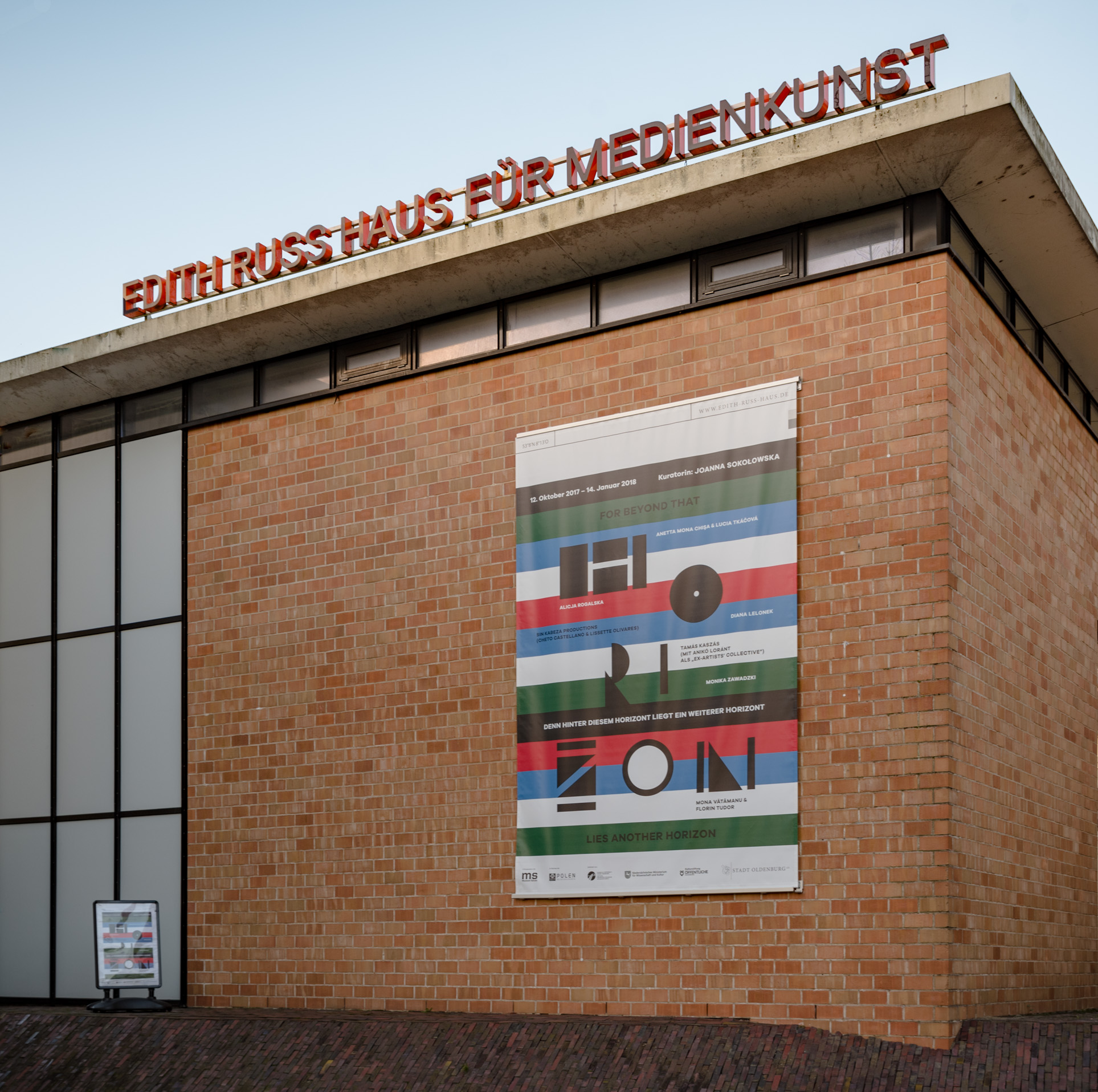 The photo shows the facade of the Edith Russ House with the banner of the exhibition For Beyond that Horizon Lies Another Horizon. Photo © Edith-Russ-Haus