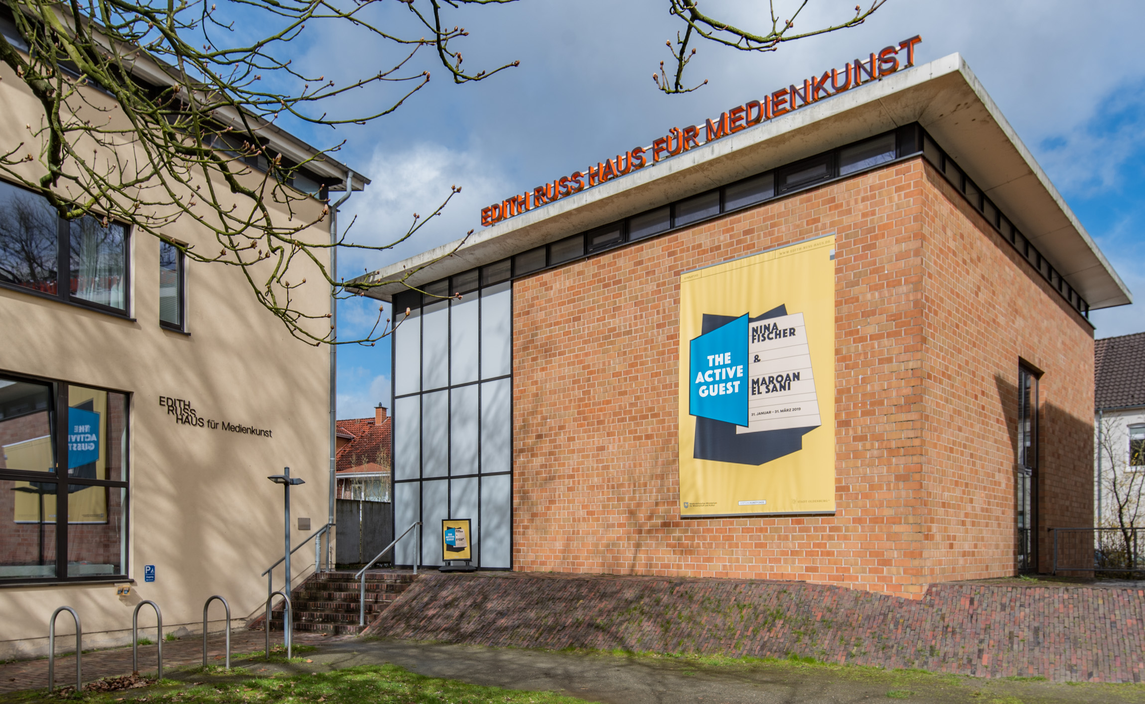 The photo shows the facade of the Edith Russ House with the banner of the exhibition Nina Fischer & Maroan el Sani: The Active Guest. Photo © Edith-Russ-Haus